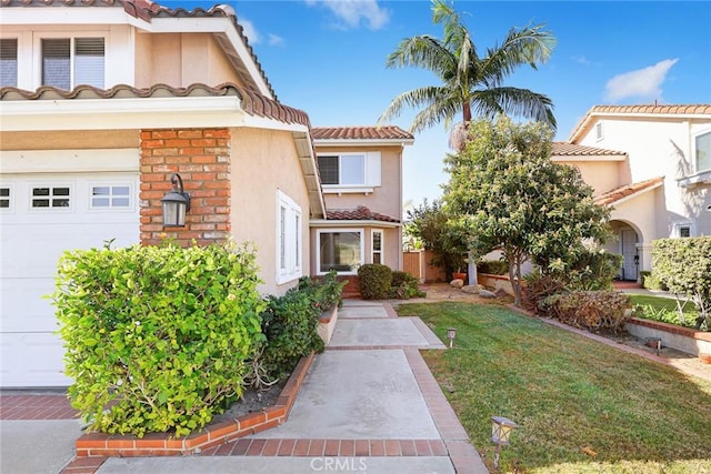 mediterranean / spanish-style house with a garage and a front lawn