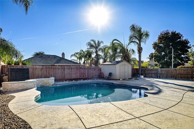 view of swimming pool featuring a patio area and a shed