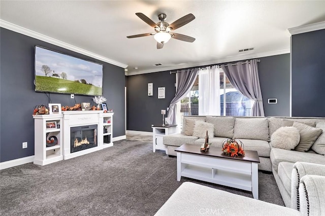 living room featuring ceiling fan, dark carpet, and crown molding