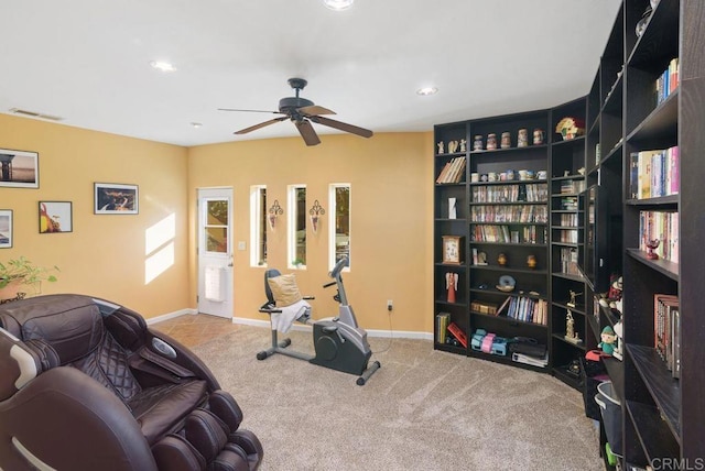 exercise room with ceiling fan and light colored carpet