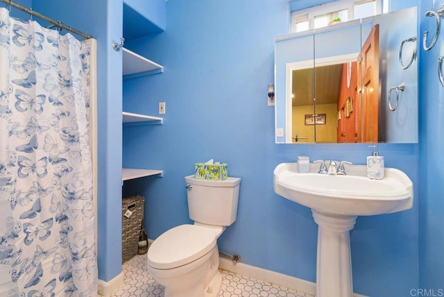 bathroom featuring tile patterned flooring, a shower with shower curtain, and toilet