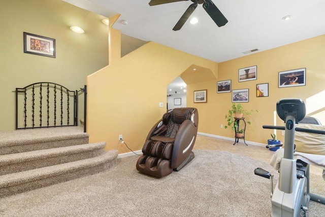 exercise room with ceiling fan and light carpet