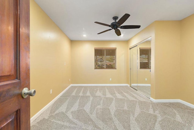 carpeted spare room with ceiling fan