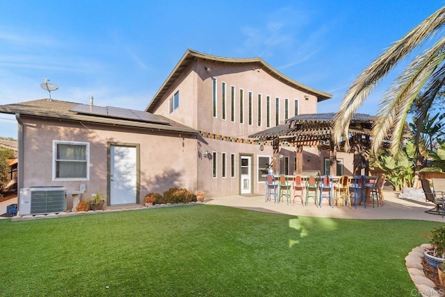 rear view of property featuring a bar, a yard, a patio, and cooling unit