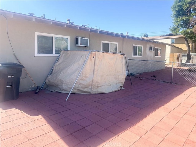 back of house featuring a wall unit AC and a patio area