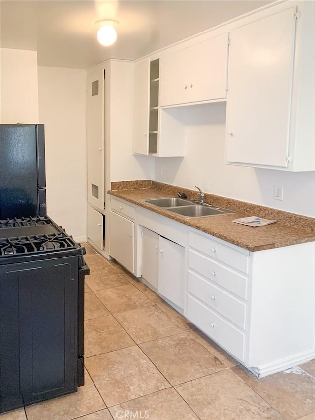 kitchen featuring white cabinets, light tile patterned floors, sink, and black appliances