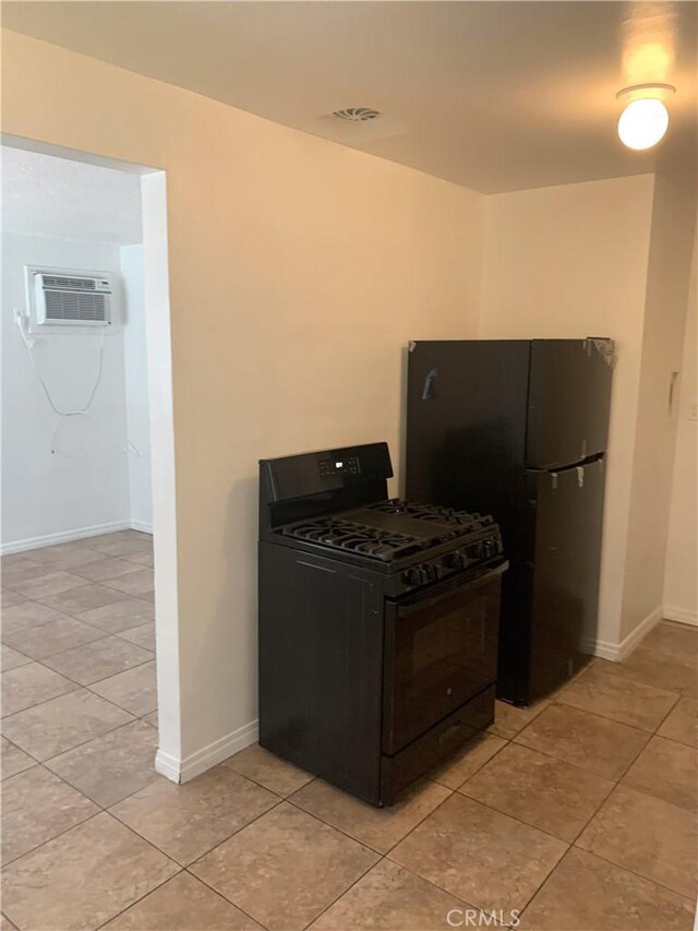 kitchen with light tile patterned floors, black appliances, and a wall mounted air conditioner