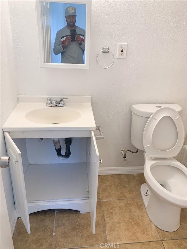 bathroom with tile patterned flooring, vanity, and toilet