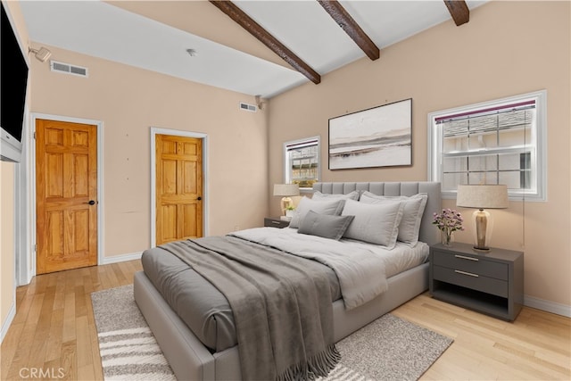 bedroom featuring vaulted ceiling with beams, ceiling fan, and light hardwood / wood-style floors