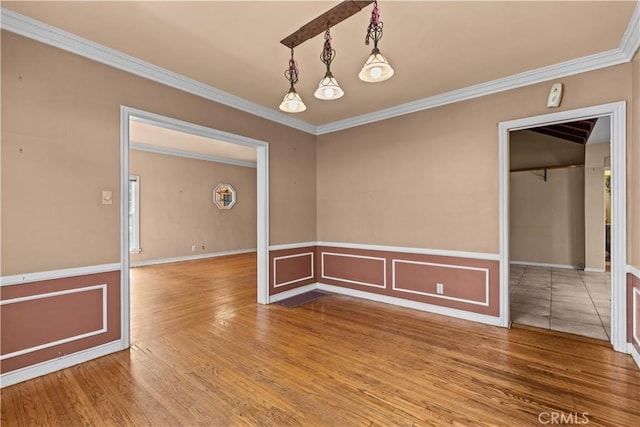 spare room with hardwood / wood-style floors and crown molding