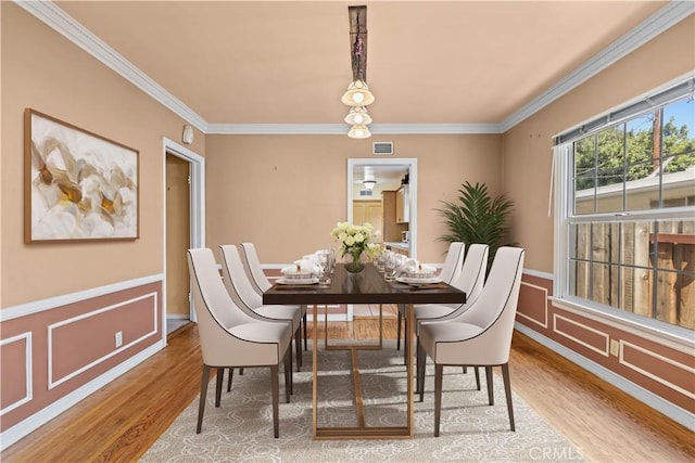 dining area featuring light hardwood / wood-style floors and ornamental molding