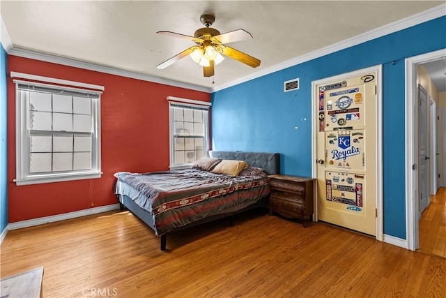 bedroom with ceiling fan, light hardwood / wood-style floors, and ornamental molding