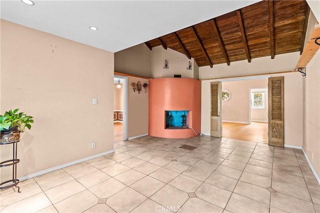 unfurnished living room featuring beamed ceiling, light tile patterned floors, high vaulted ceiling, and wood ceiling