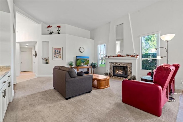 carpeted living room featuring a fireplace and a high ceiling