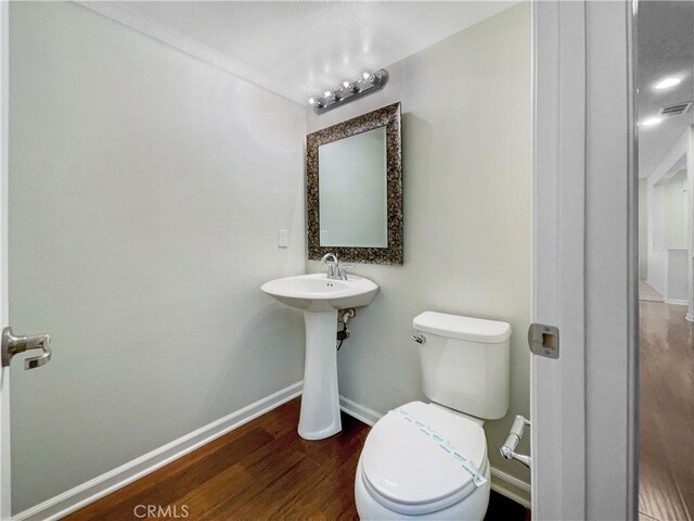 bathroom with sink, hardwood / wood-style floors, and toilet