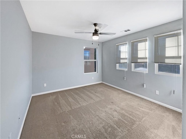 carpeted spare room featuring ceiling fan