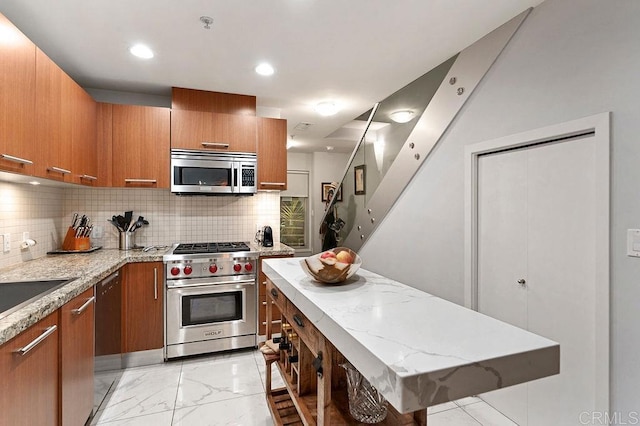 kitchen with a kitchen island, light stone counters, stainless steel appliances, and tasteful backsplash