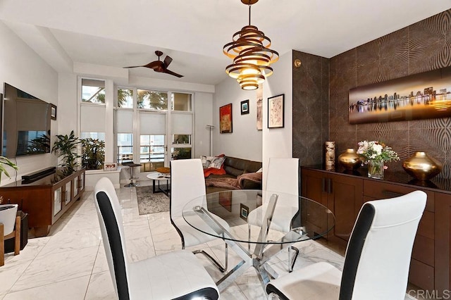 dining space with ceiling fan with notable chandelier