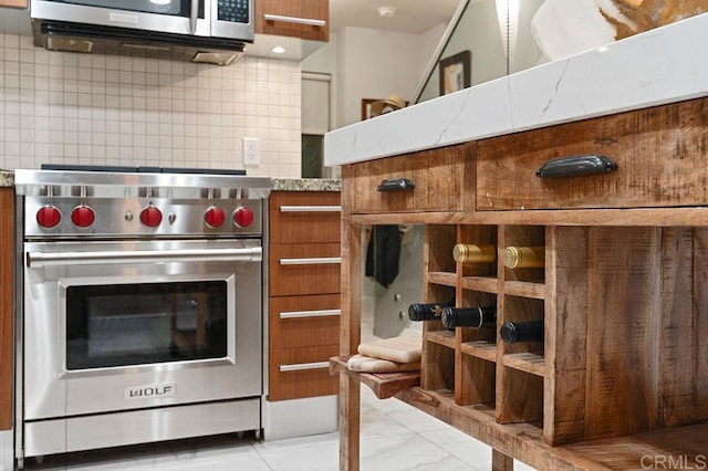 kitchen featuring decorative backsplash, light stone counters, and stainless steel appliances