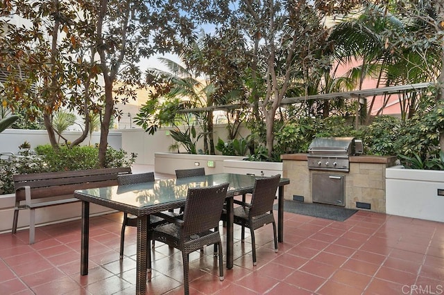 patio terrace at dusk with grilling area and an outdoor kitchen