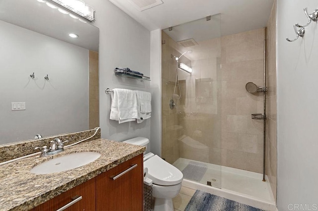 bathroom featuring tile patterned floors, a shower with door, vanity, and toilet