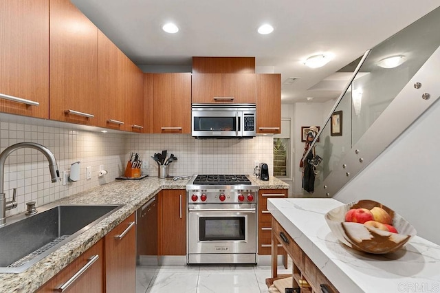 kitchen with decorative backsplash, sink, light stone counters, and stainless steel appliances