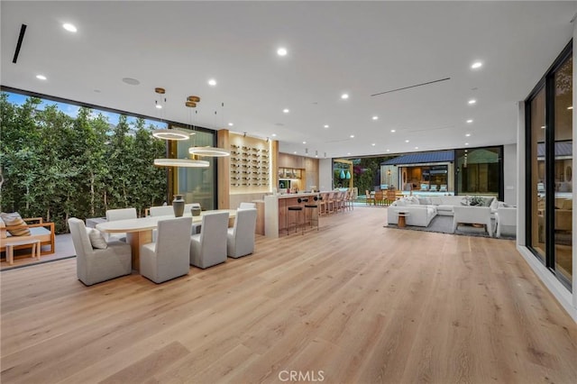 living room with a healthy amount of sunlight, light hardwood / wood-style floors, and a wall of windows