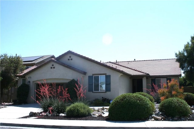 view of front of house featuring solar panels and a garage