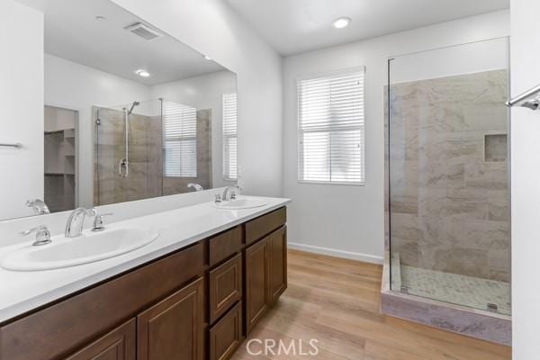 bathroom featuring vanity, wood-type flooring, and a shower with door