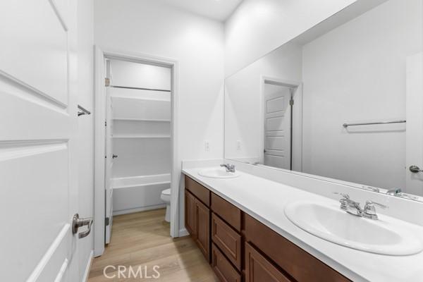 bathroom with vanity, hardwood / wood-style floors, and toilet