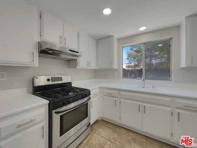 kitchen with white cabinets, light tile patterned floors, sink, and stainless steel range with gas stovetop