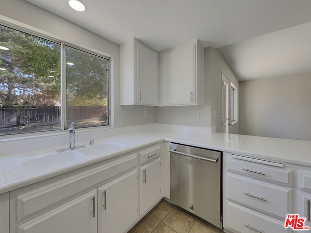 kitchen with sink, white cabinets, stainless steel dishwasher, kitchen peninsula, and light tile patterned flooring