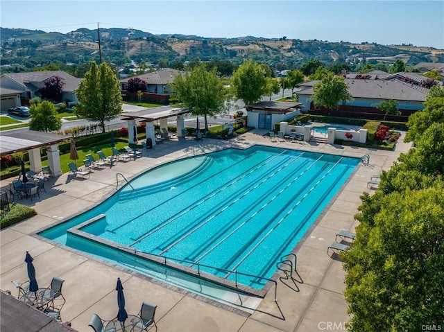 view of swimming pool featuring a patio area and a mountain view