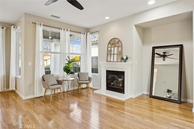 living area featuring ceiling fan and light hardwood / wood-style flooring