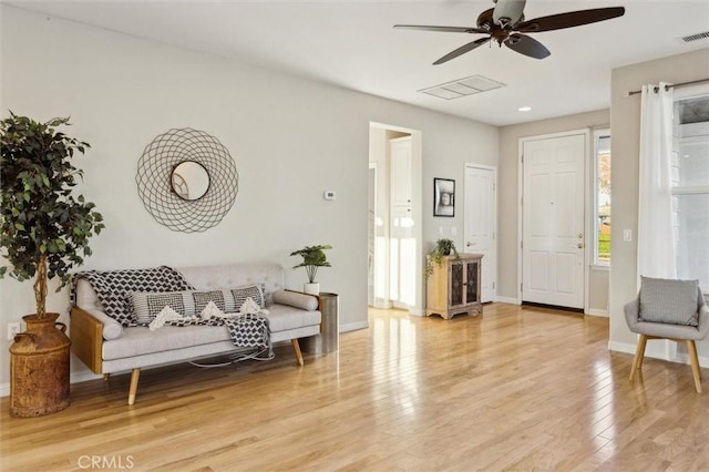 living area with ceiling fan and light hardwood / wood-style floors