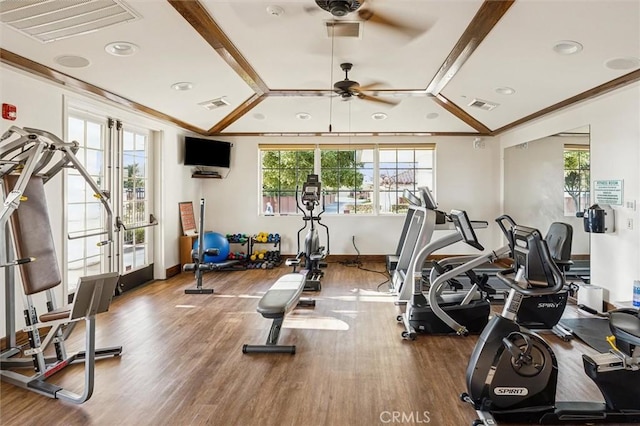 gym featuring vaulted ceiling, ceiling fan, ornamental molding, and hardwood / wood-style flooring