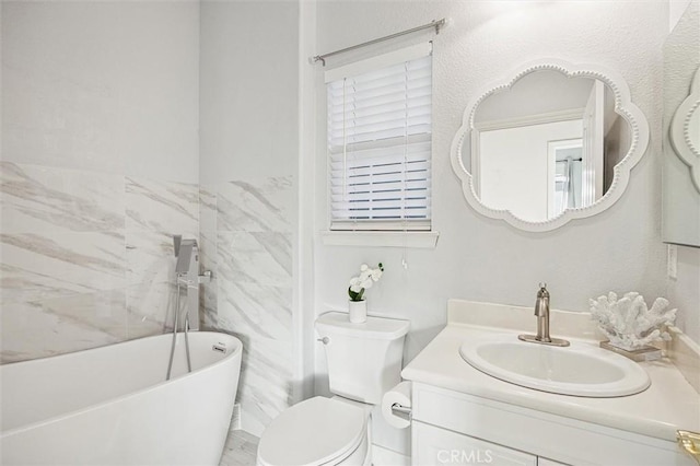 bathroom featuring vanity, toilet, and a tub