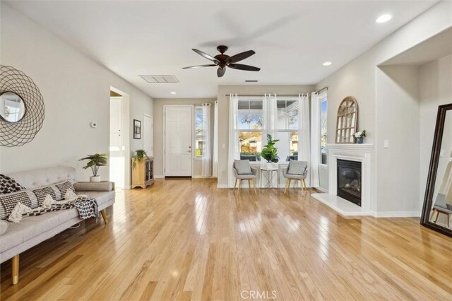 living room featuring ceiling fan and light hardwood / wood-style flooring