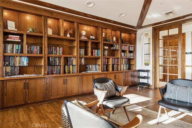 living area featuring beam ceiling, dark hardwood / wood-style floors, and built in shelves