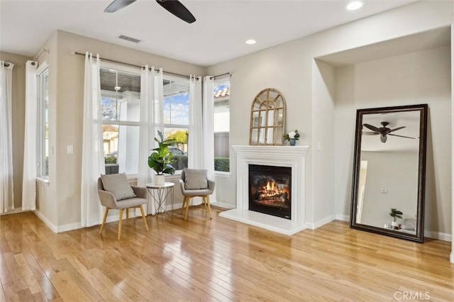 living area with ceiling fan and light hardwood / wood-style floors