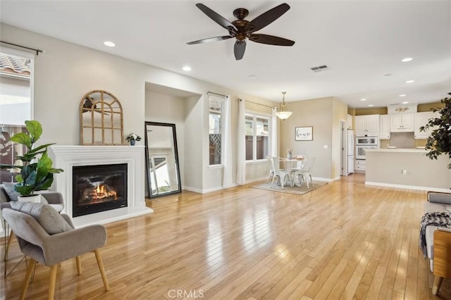 living room with ceiling fan and light hardwood / wood-style floors