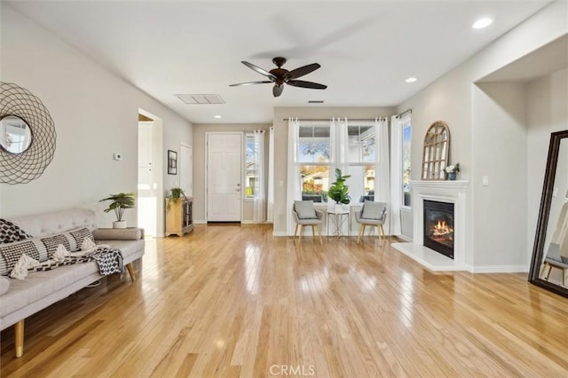 living room featuring light wood-type flooring and ceiling fan