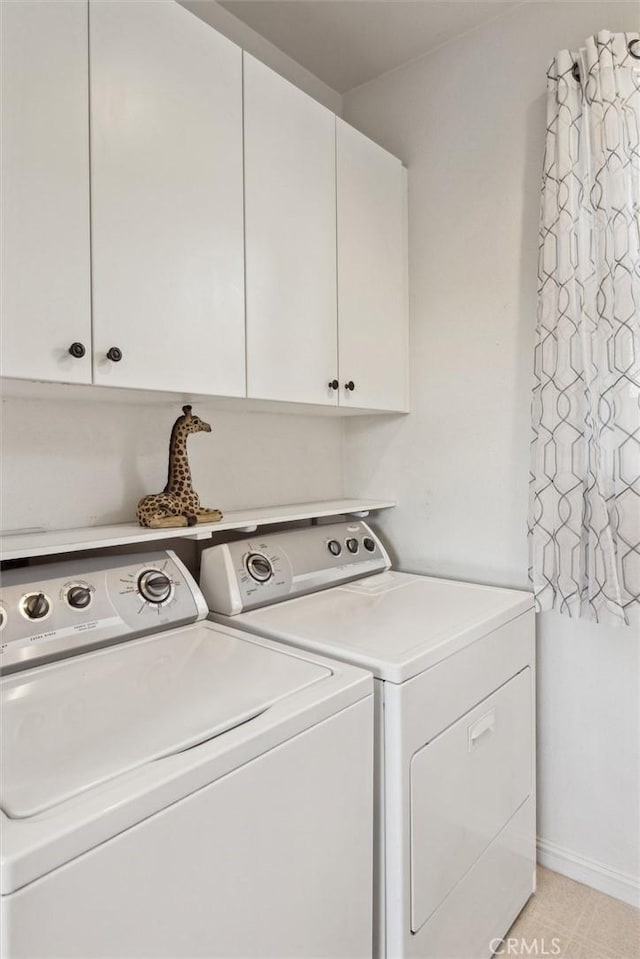 laundry area featuring washer and dryer, cabinets, and light tile patterned floors