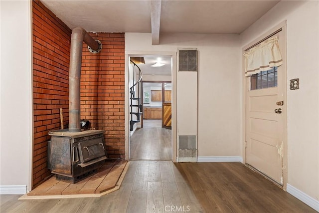 entrance foyer featuring hardwood / wood-style flooring and a wood stove