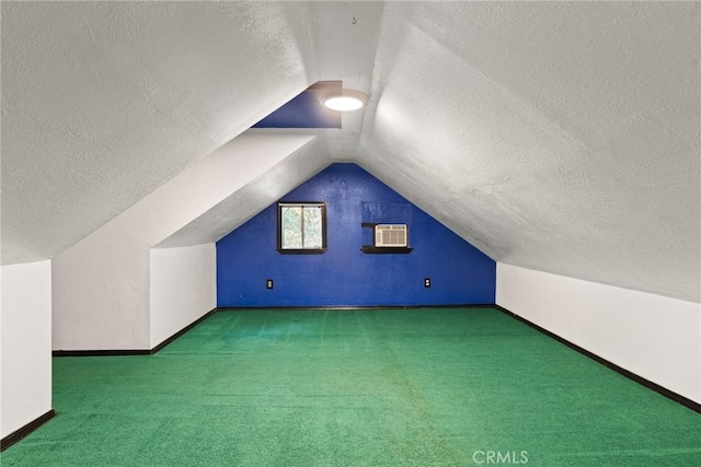 additional living space featuring carpet floors, a textured ceiling, a wall unit AC, and vaulted ceiling