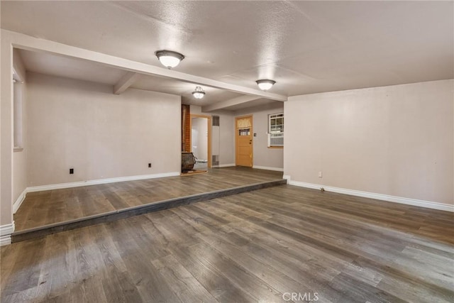 basement featuring a textured ceiling and dark wood-type flooring