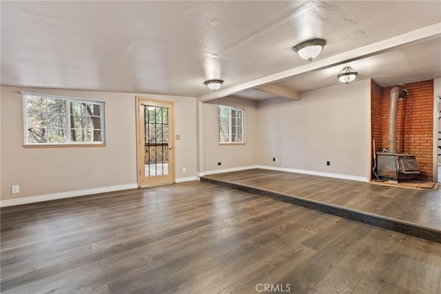 unfurnished living room with dark hardwood / wood-style flooring and a wood stove