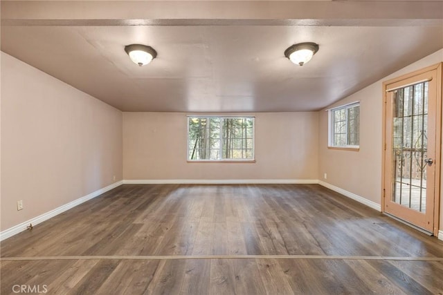 unfurnished room with dark wood-type flooring and vaulted ceiling