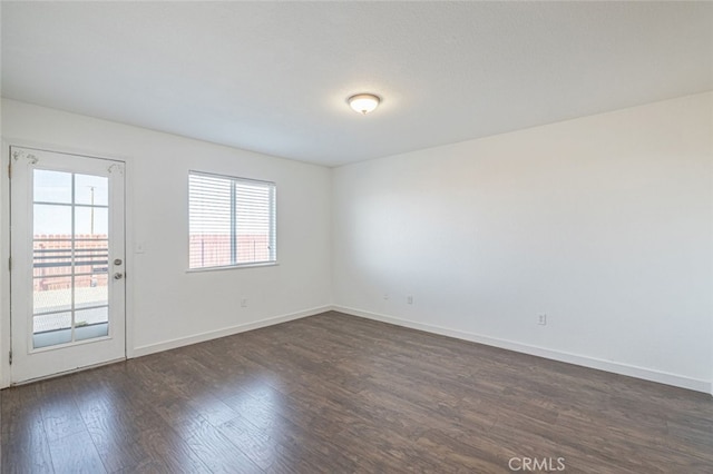 empty room featuring dark hardwood / wood-style flooring and a healthy amount of sunlight