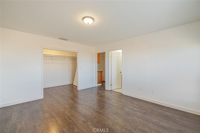 unfurnished bedroom with a closet and dark wood-type flooring